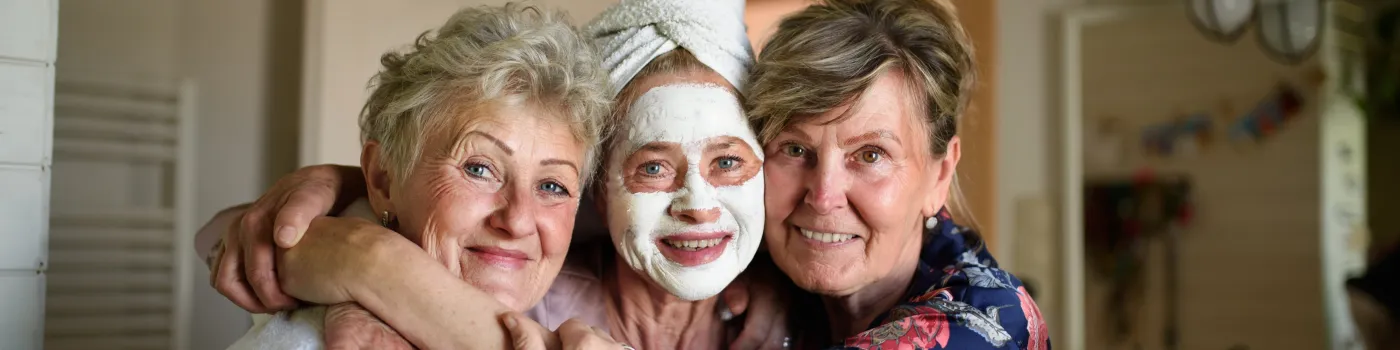 Three elderly women smiling, practice some skin care. 