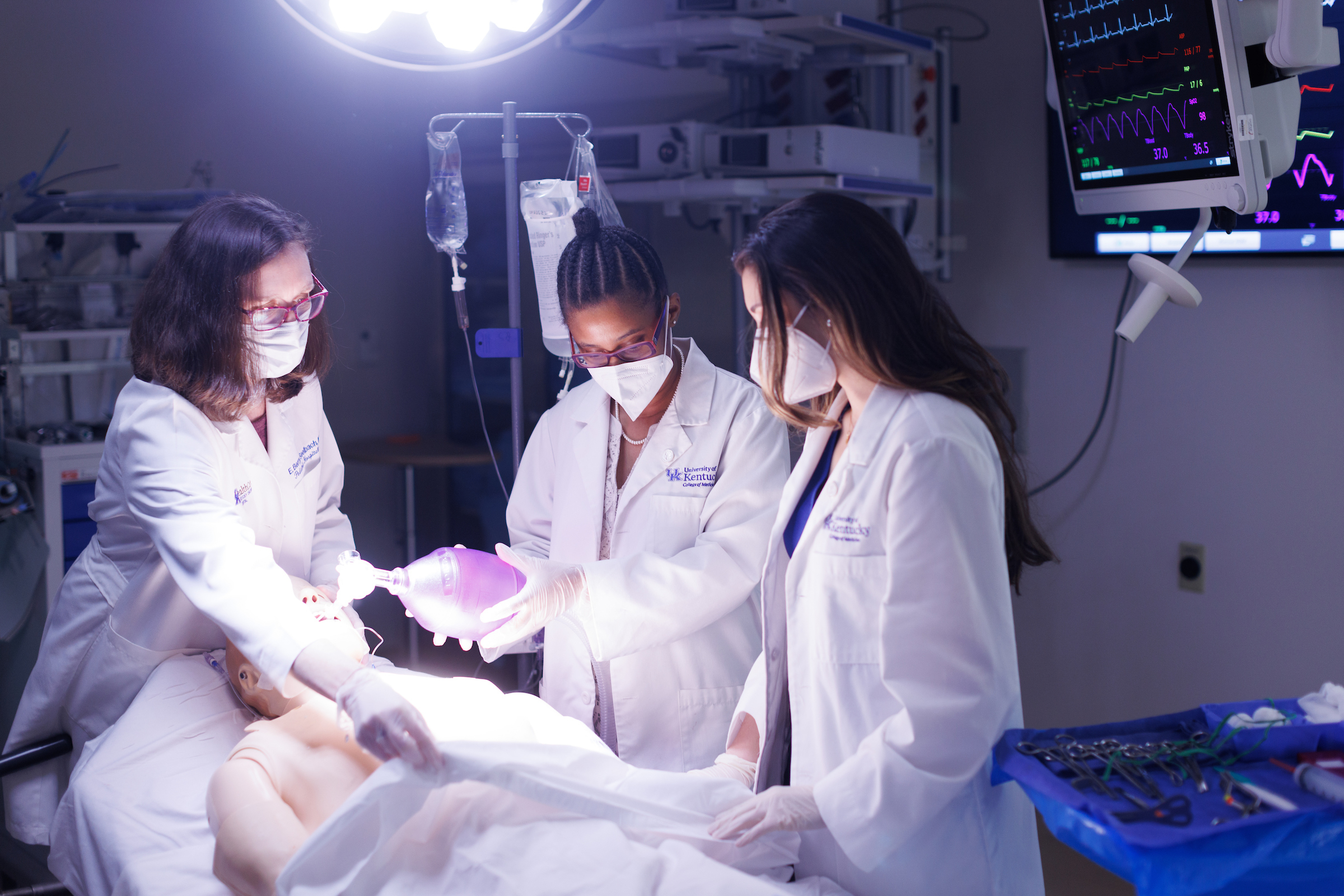A professor and students work in a simulation surgery.