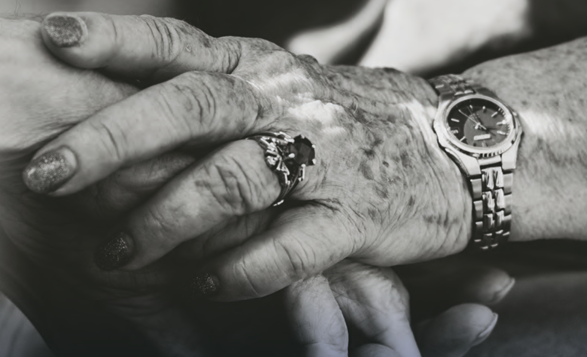 Close up of elderly people holding hands.