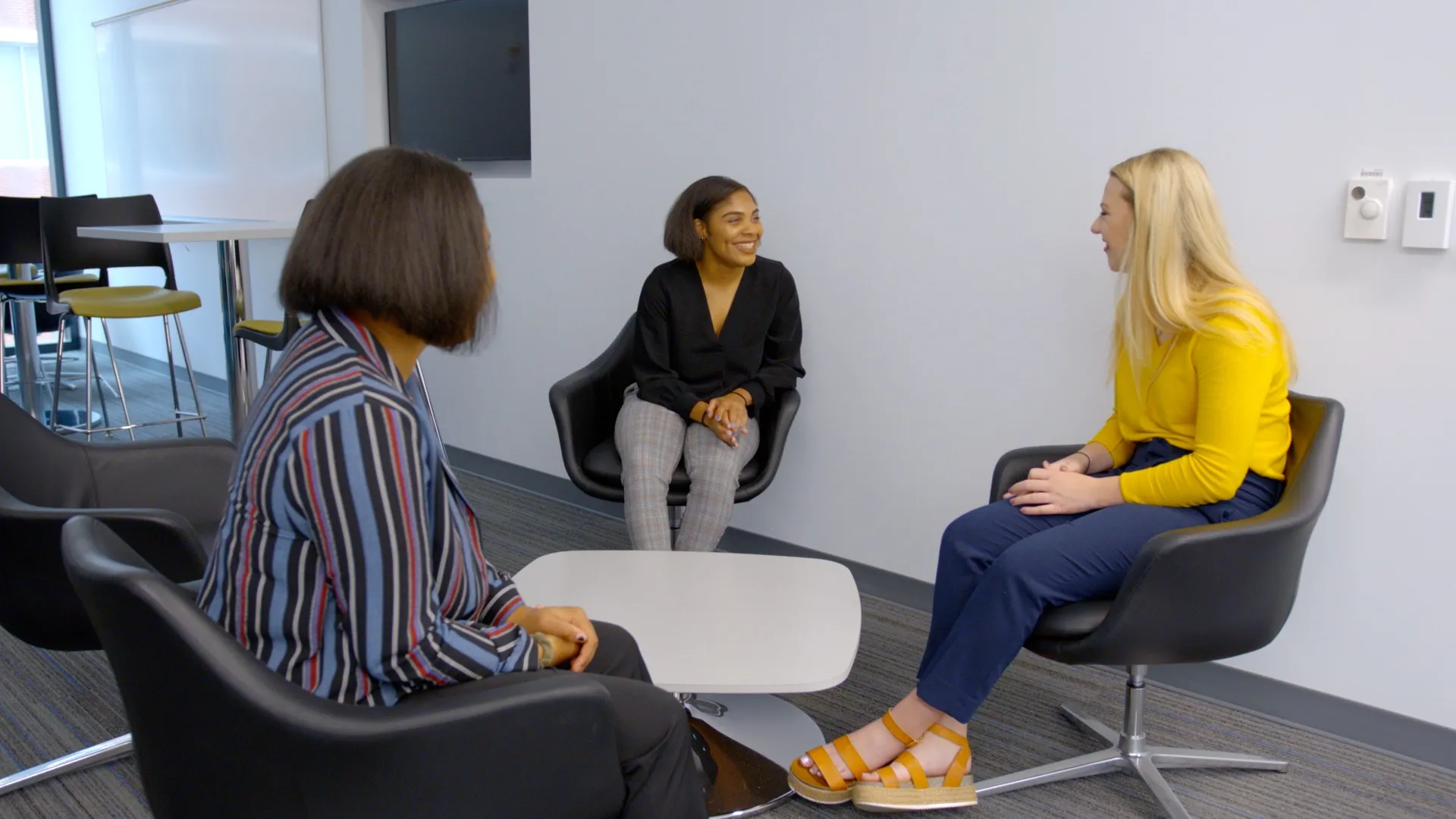 3 individuals sitting in chairs facing each other