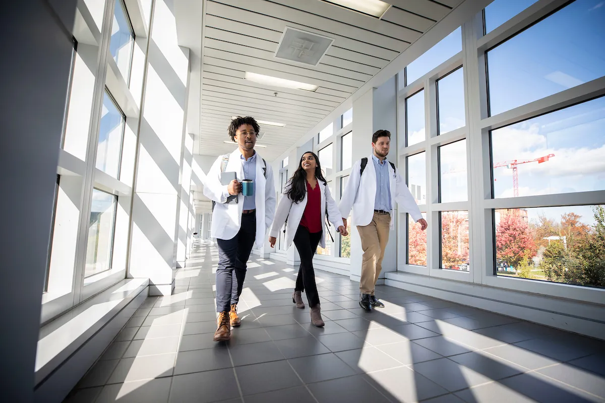 3 medical students walking down a hallway