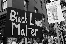 Poster says "Black Lives Matter" and a crowd below