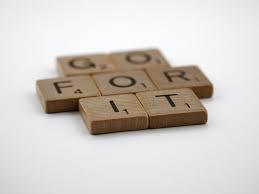 the words "Go For It" written out in Scrabble wooden square tiles