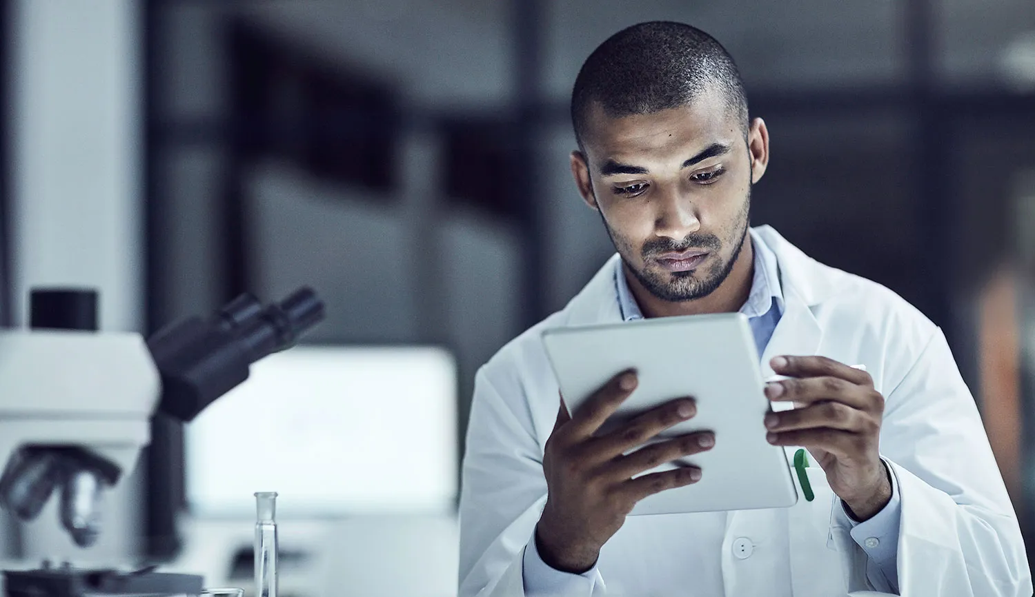 researcher reviewing a report with a microscope to the side