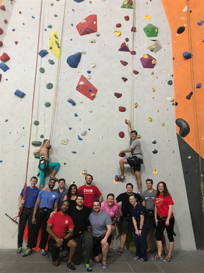 Group photo of residents at an indoor rock climbing facility