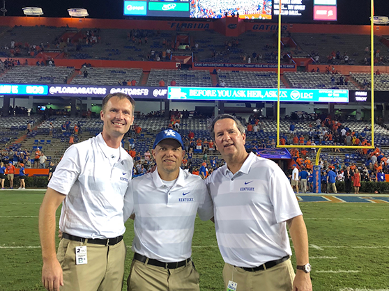 Three sports medicine faculty at a football game.