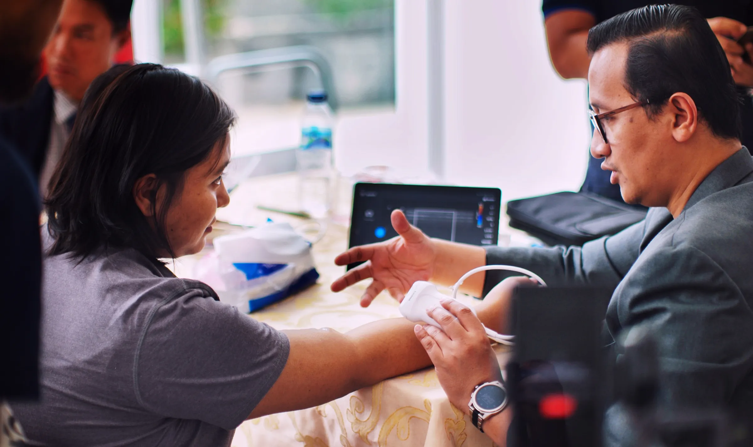 Doctor performing ultrasound on patient's wrist