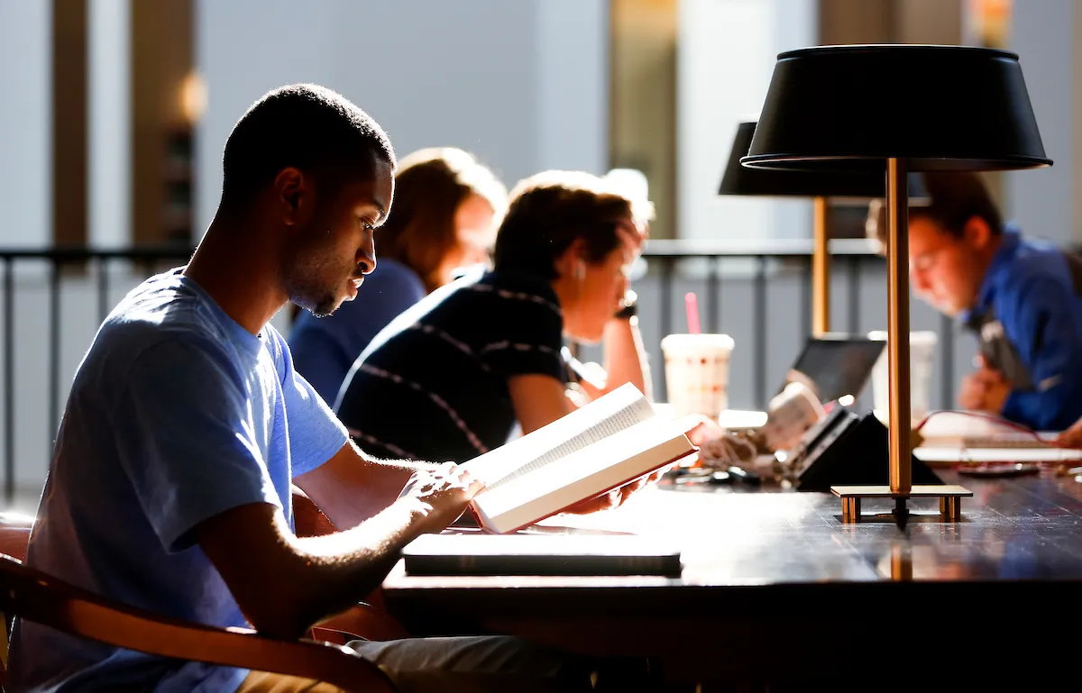 undergraduate student at library reading table