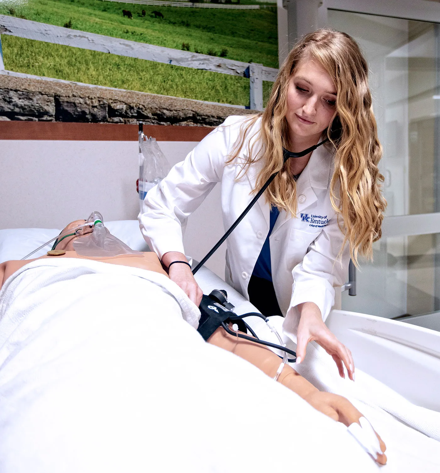 medical student examining a medical manikin