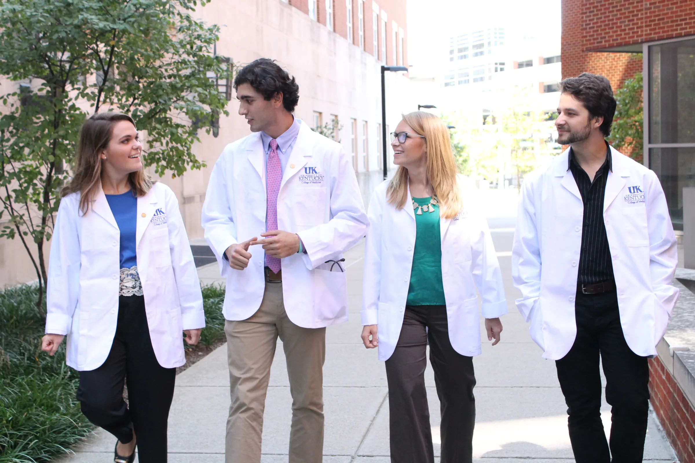 group of medical students walking outside on sidewalk