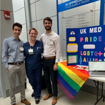 Three students with LGBTQ flag