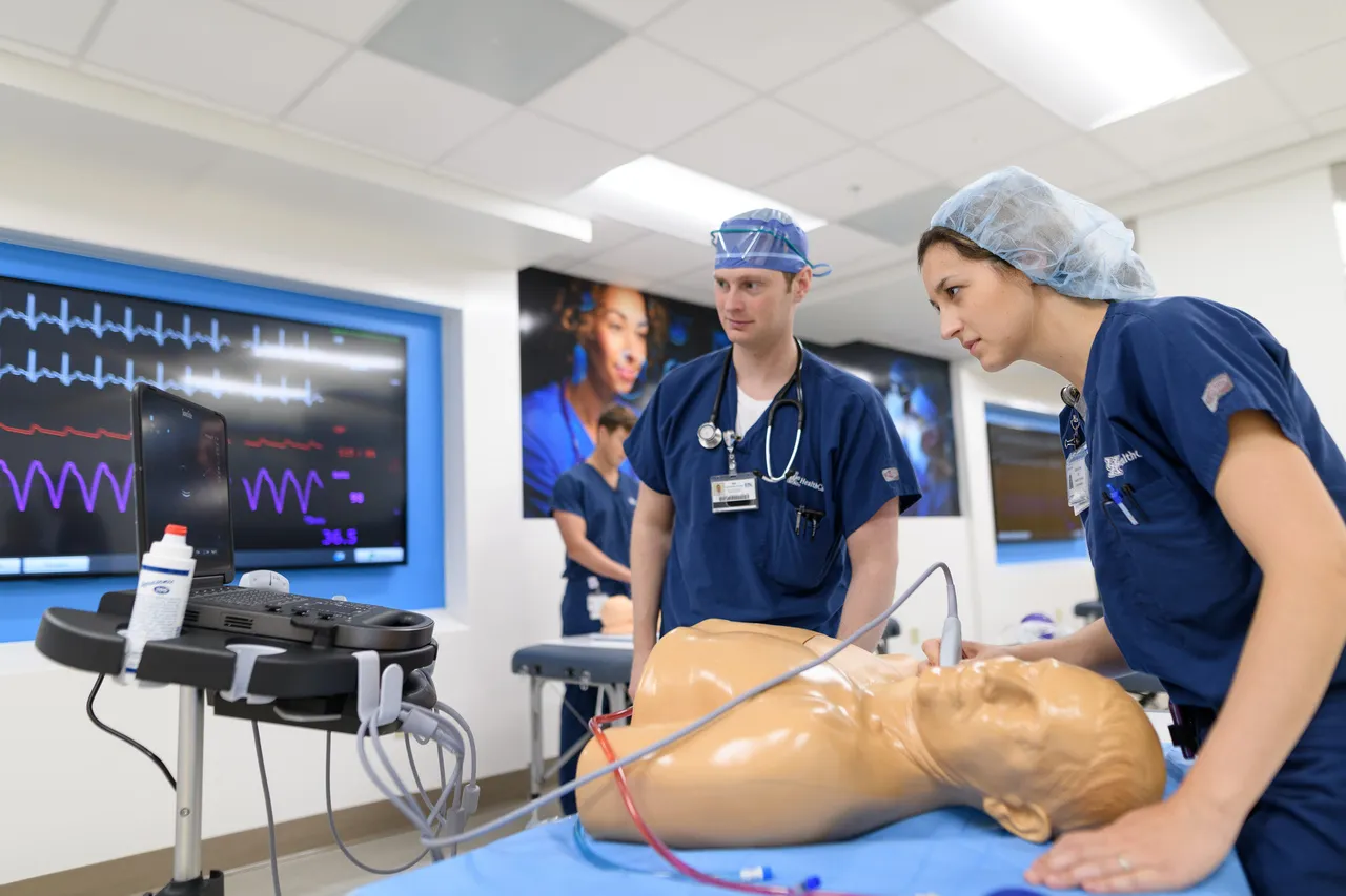 simulation lab with two medical students performing a ultrasound on a medical manikin