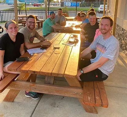 student running club sitting around picnic table