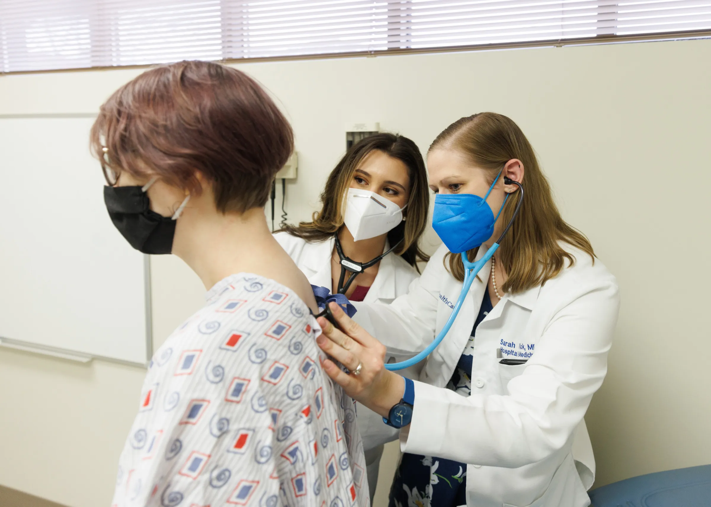 Two female doctors checking on a patient.