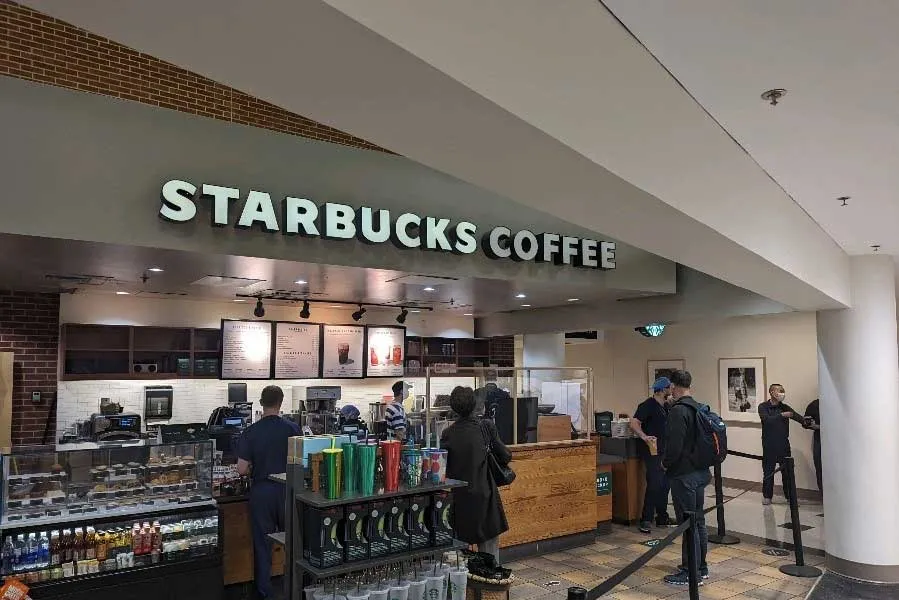 Starbucks inside Chandler Hospital; refrigerator case, glass display, order counter, patrons standing around