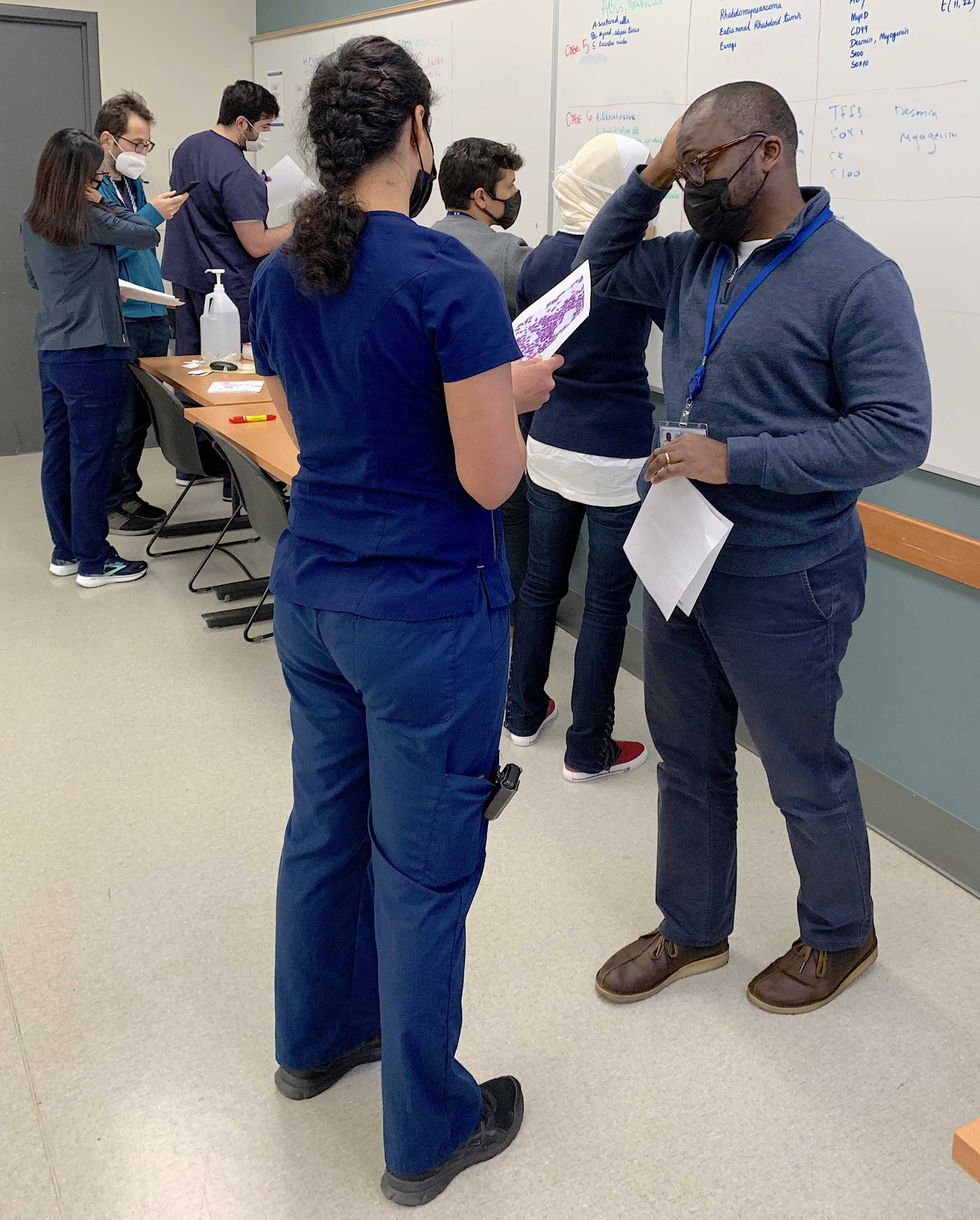 Drs. Asma Arshia and Leonard Yenwongfai discuss the differential diagnosis of metaphyseal bone tumors during a team learning experience.