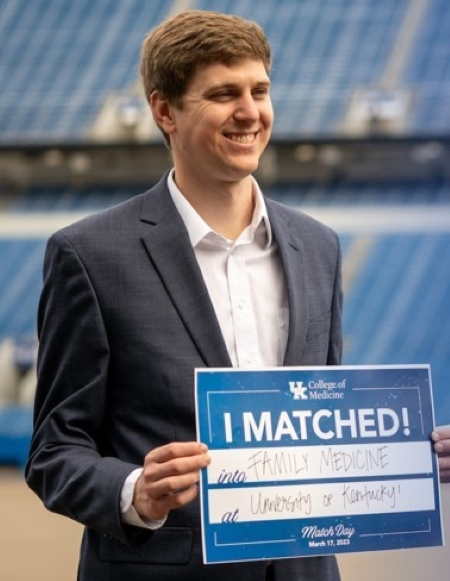University of Kentucky medical student holding sign saying they matched into the Uk Family Medicine Residency program.