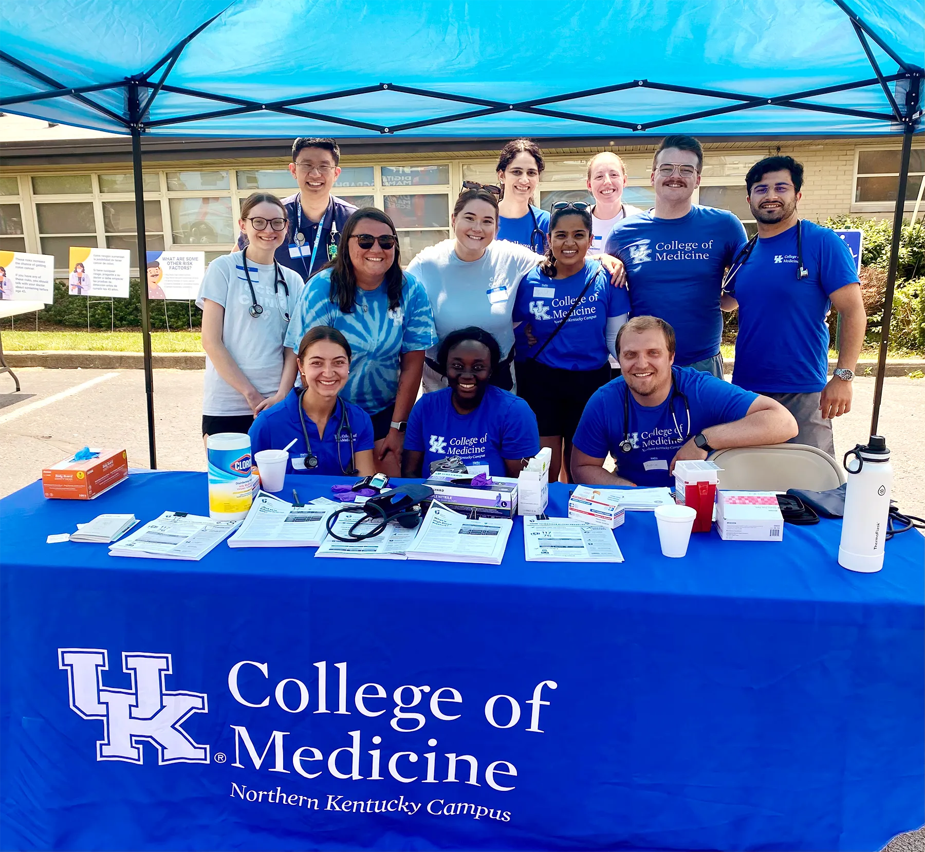 students smiling at an outdoor booth