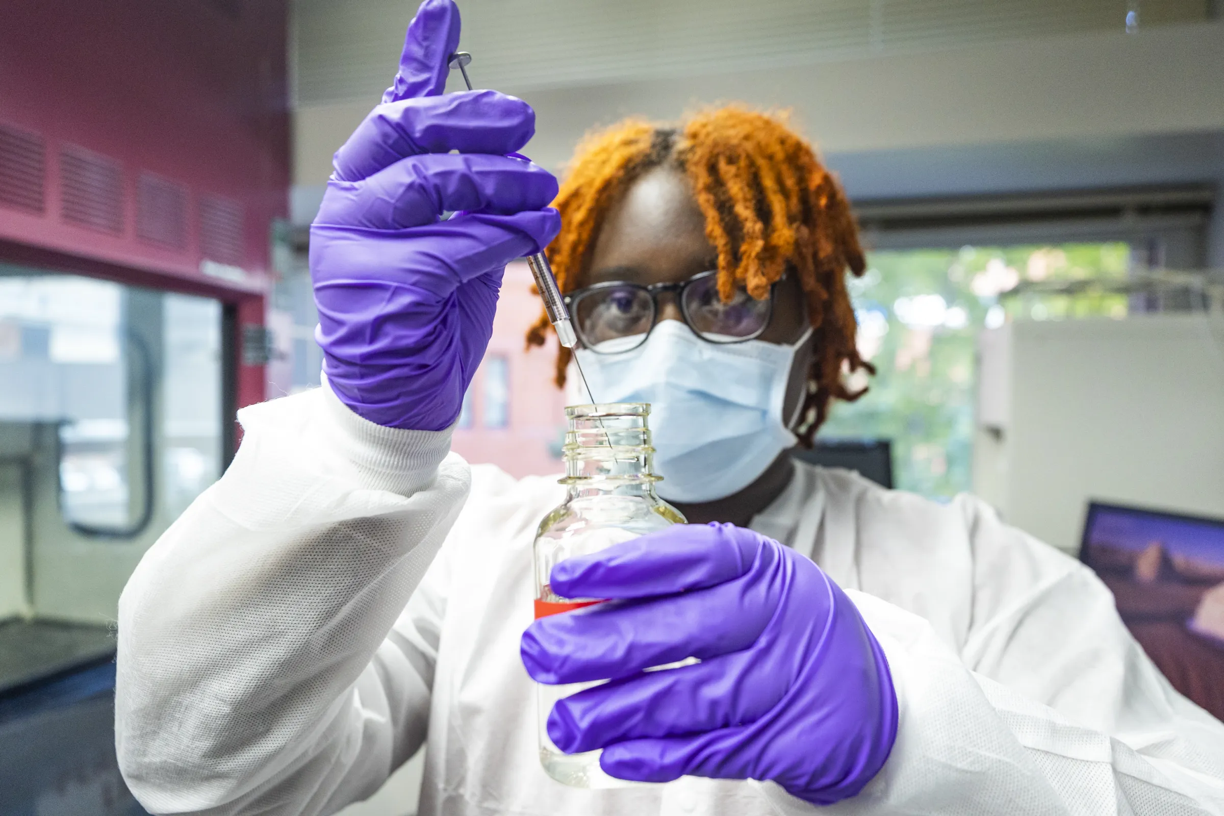 Student working in lab with small measurement of a chemical