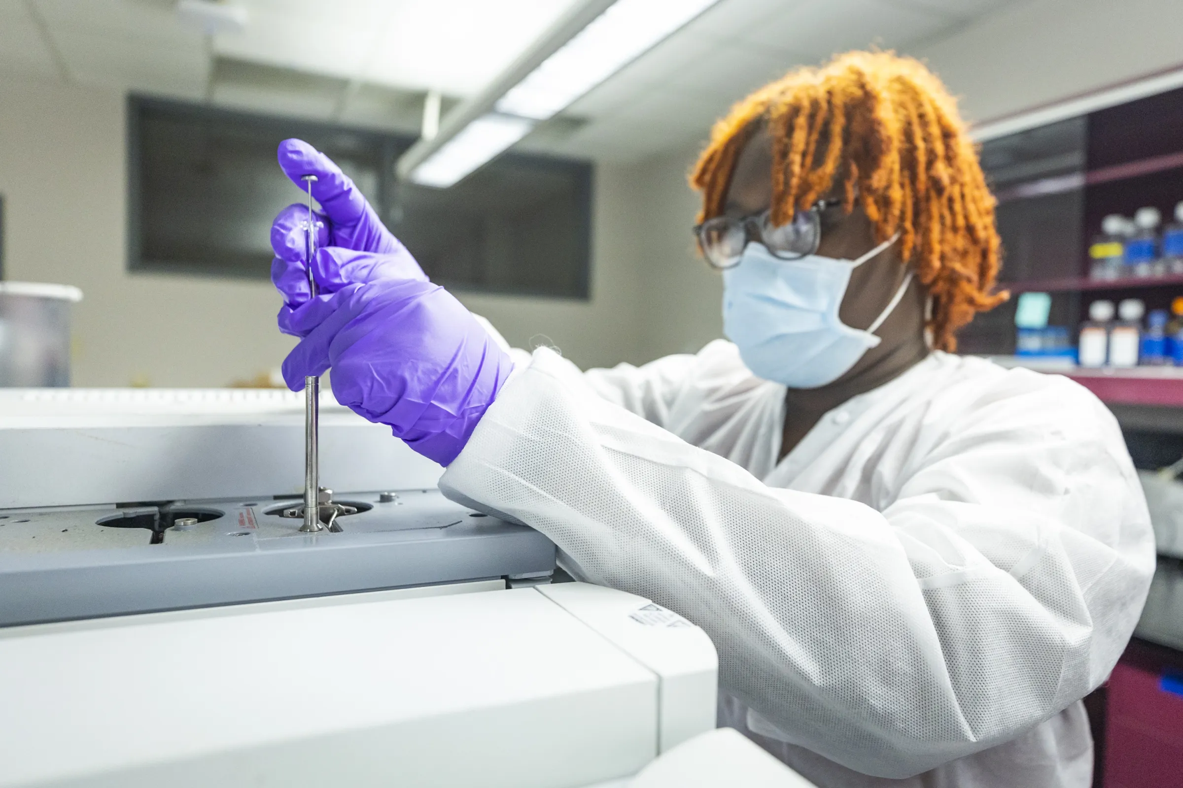 Student working in lab with pipette.