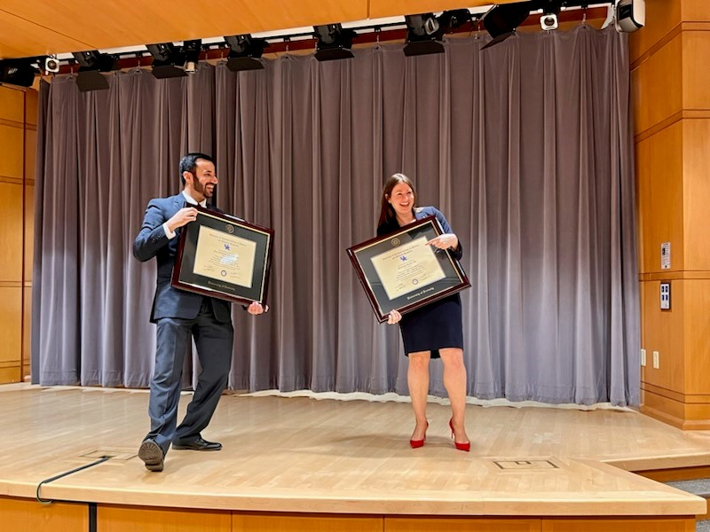 Maher Ajour and Mandy Brasher dancing onstage with their diplomas.