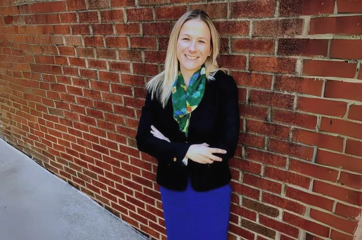 Maggie Murphy, PhD in front of a brick wall.