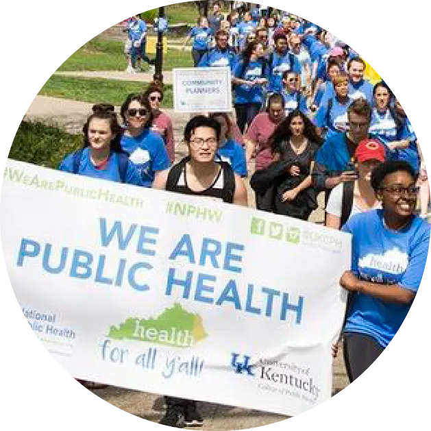 students marching for public health with a banner that says "we are public health"