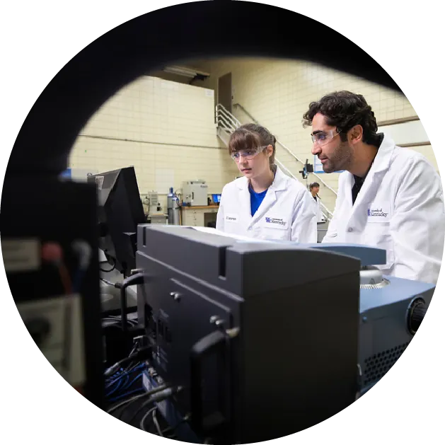 researcher and student in a lab looking at a biosystem