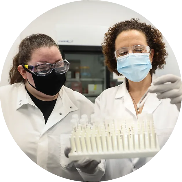 two researchers looking at vials 