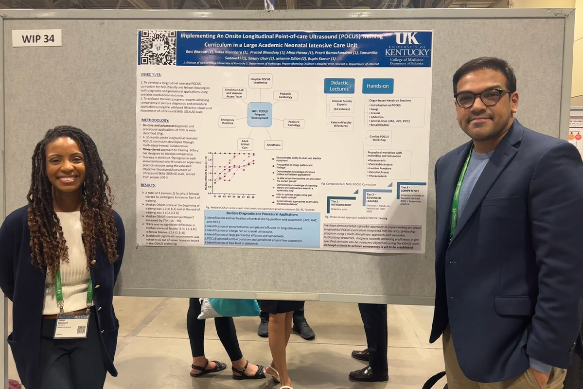 Fellows Ianna Blanchard and Ravi Bhavsar stop for a photo with their poster. 