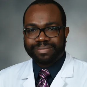 Headshot of Dr. Akemokwe wearing a labcoat