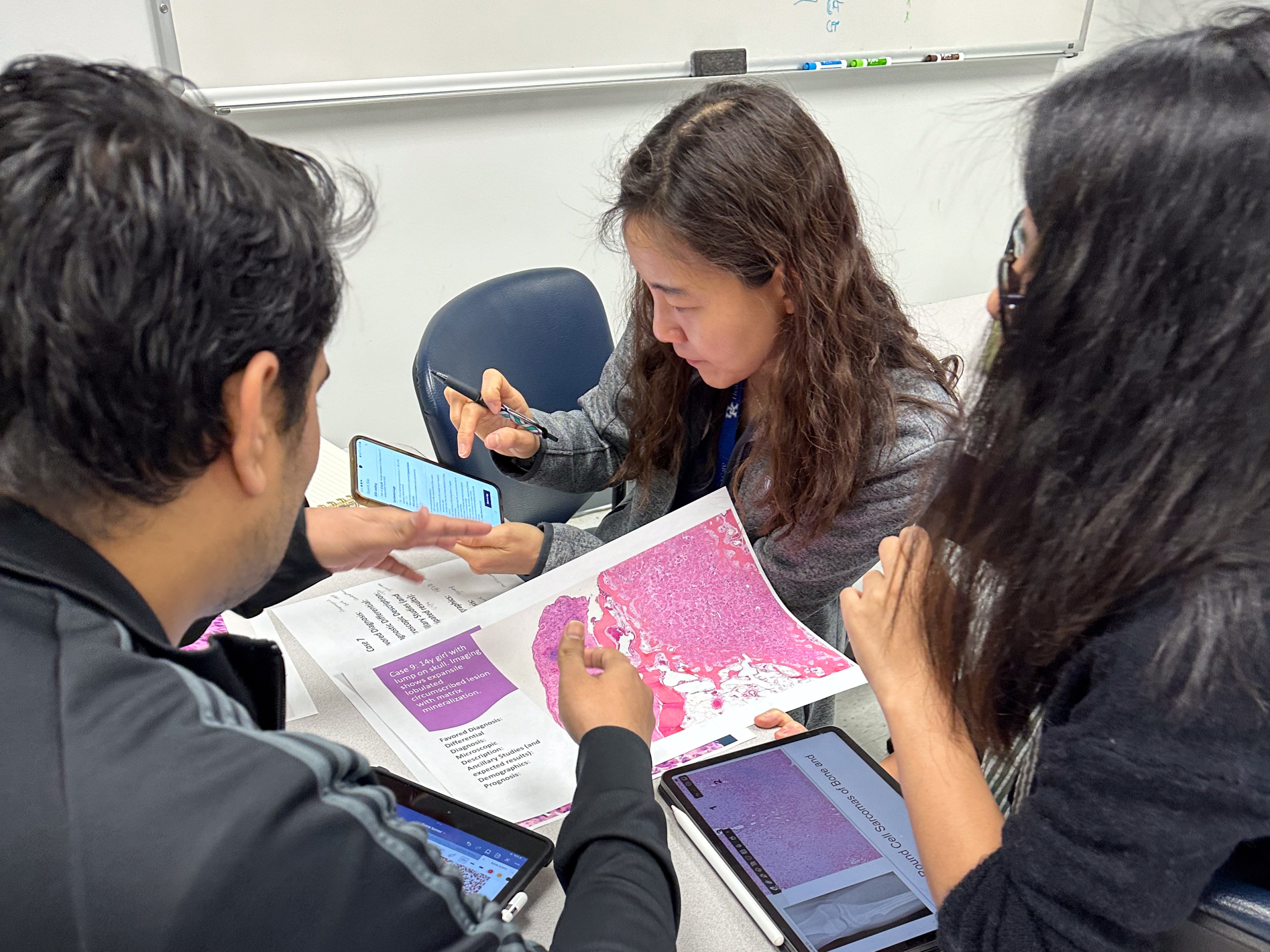 Drs. Talal Arshad, Jeongeun Do, and Jing Di assess cytologic features of a soft tissue tumor during a team learning experience.