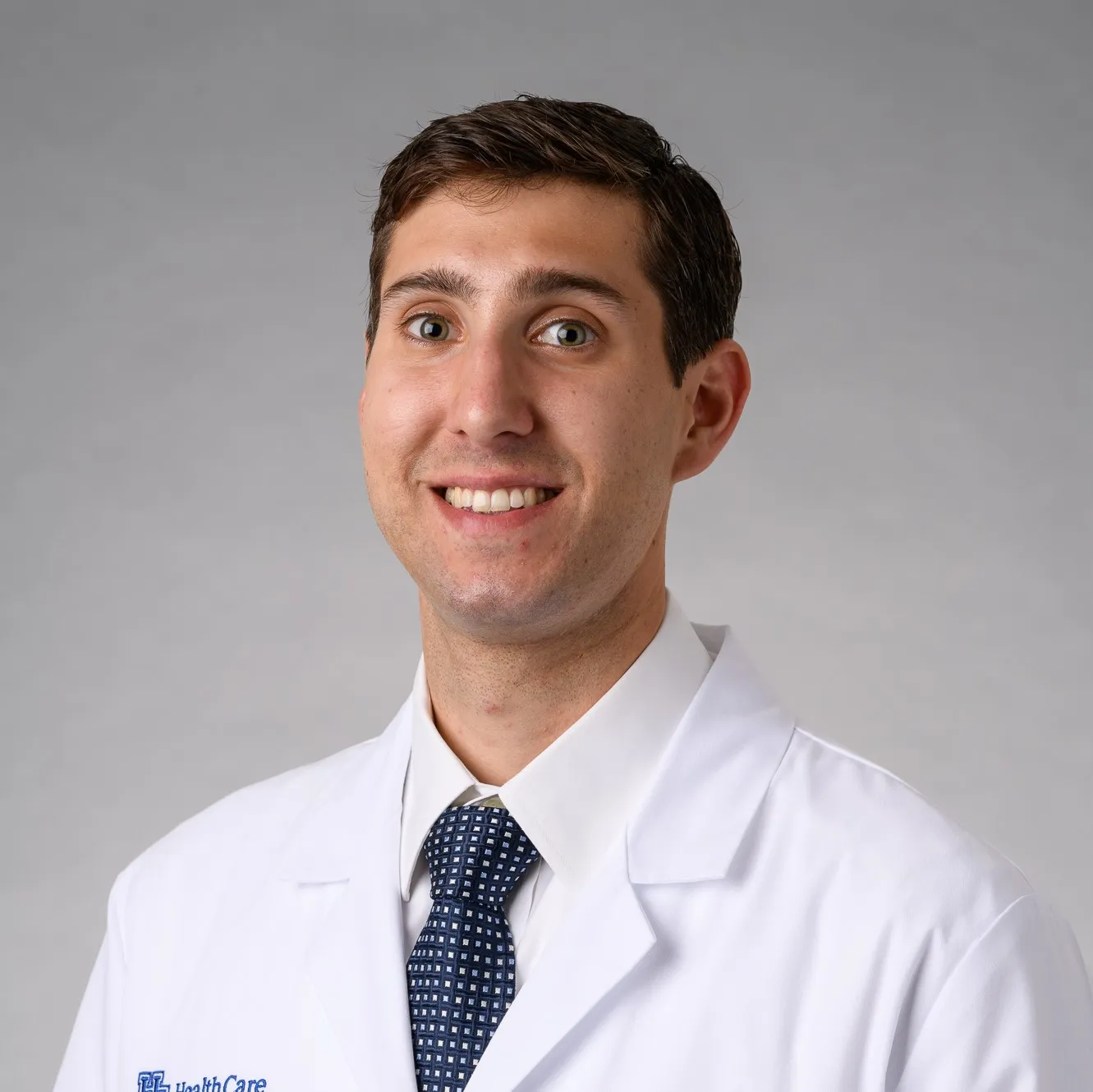 Nick Fowler smiling in white coat.