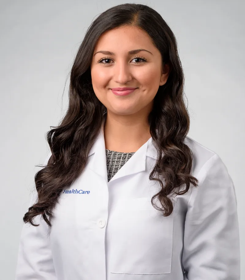 Tania smiling in white coat