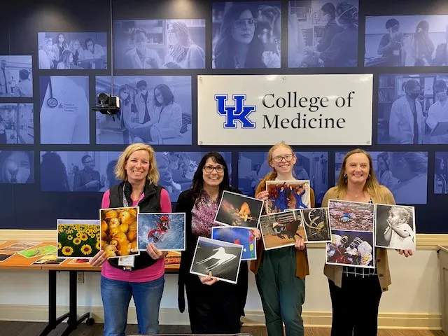 4 woman standing holding images