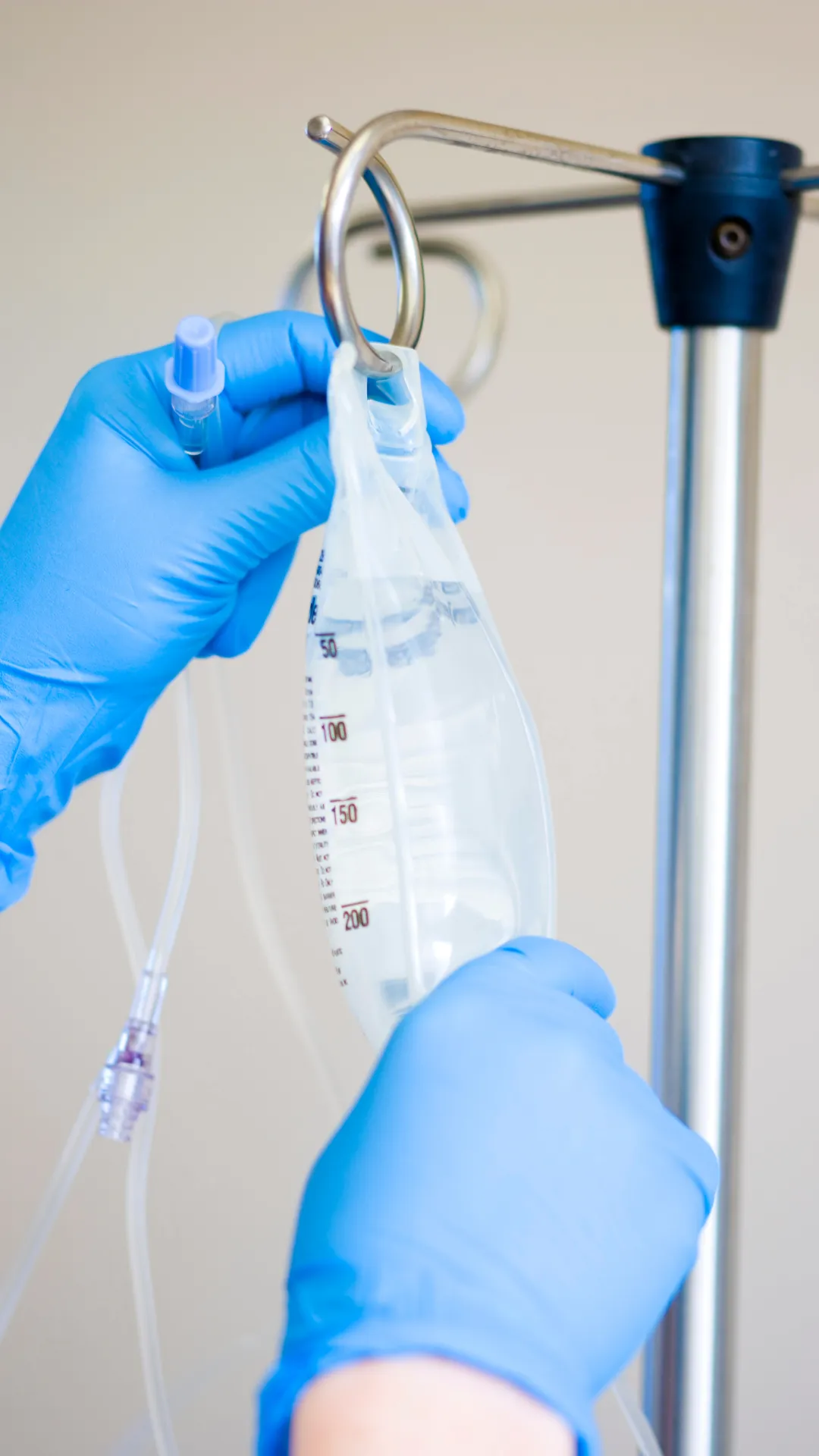 Blue rubber gloves hang up an IV Drip