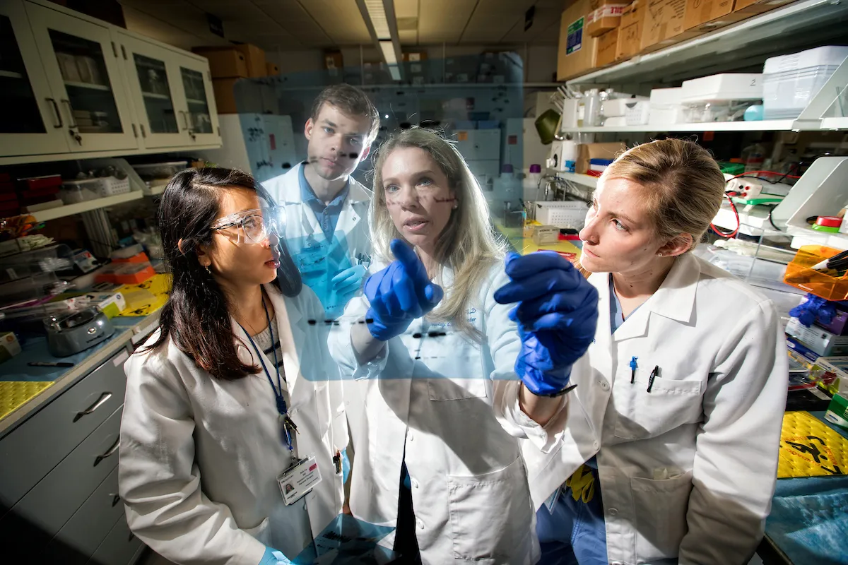Female mentor with two female students and one male student looking at X-ray
