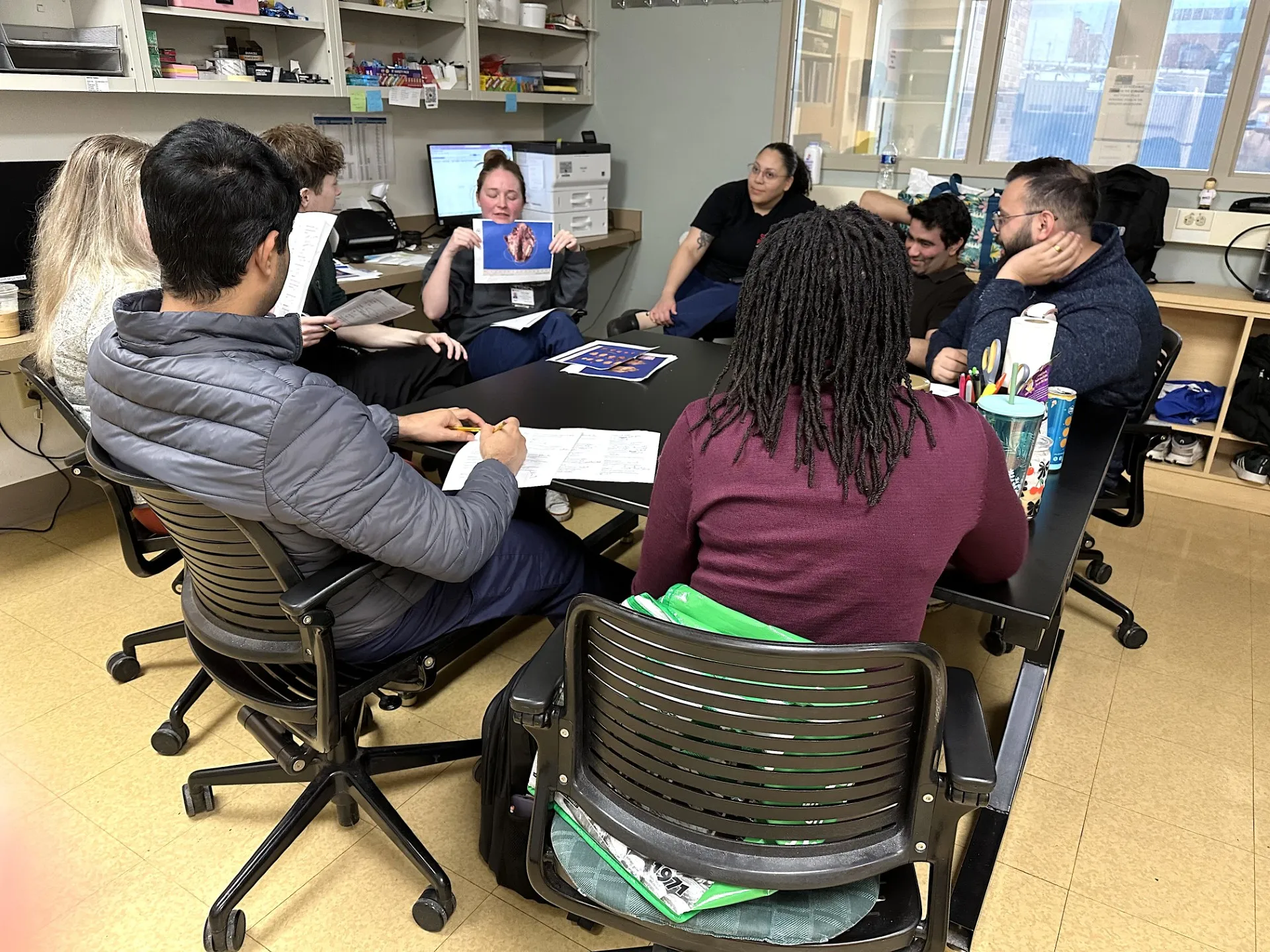 This is an image of pathology residents discussing a specimen with a Pathologists' Assistant