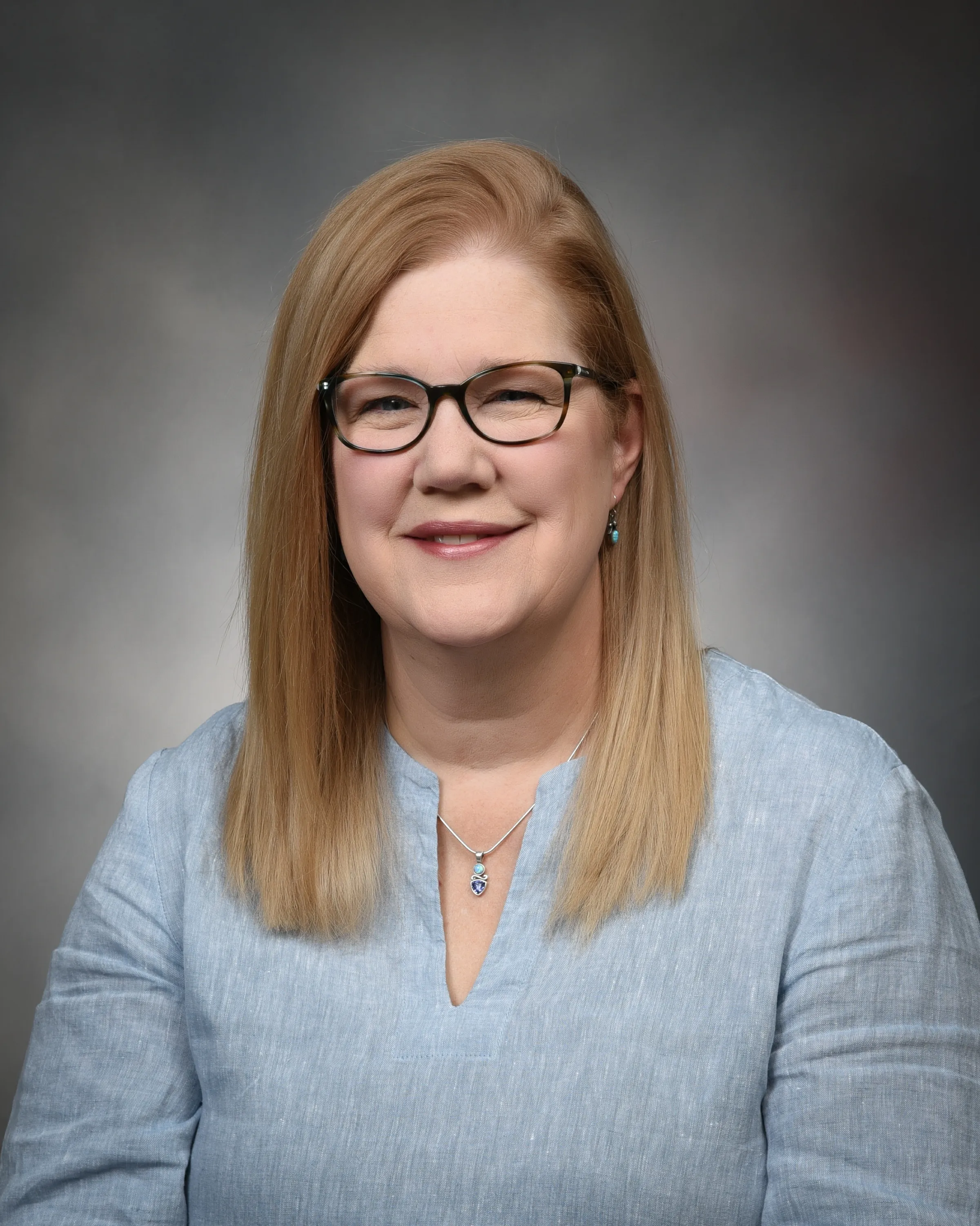 A headshot of Dr. Elizabeth Schroder Stumpf in a blue blouse