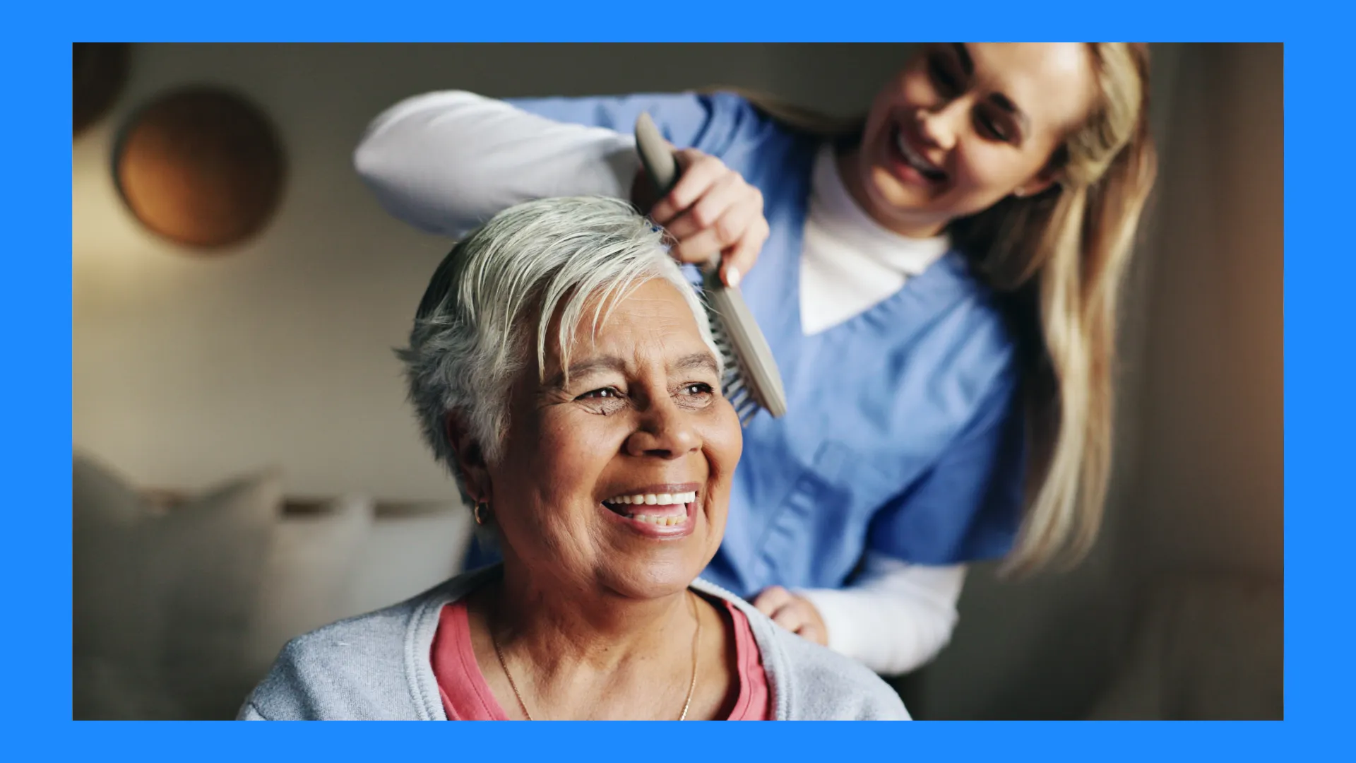 A nurse brushing an elderly woman's hair. 