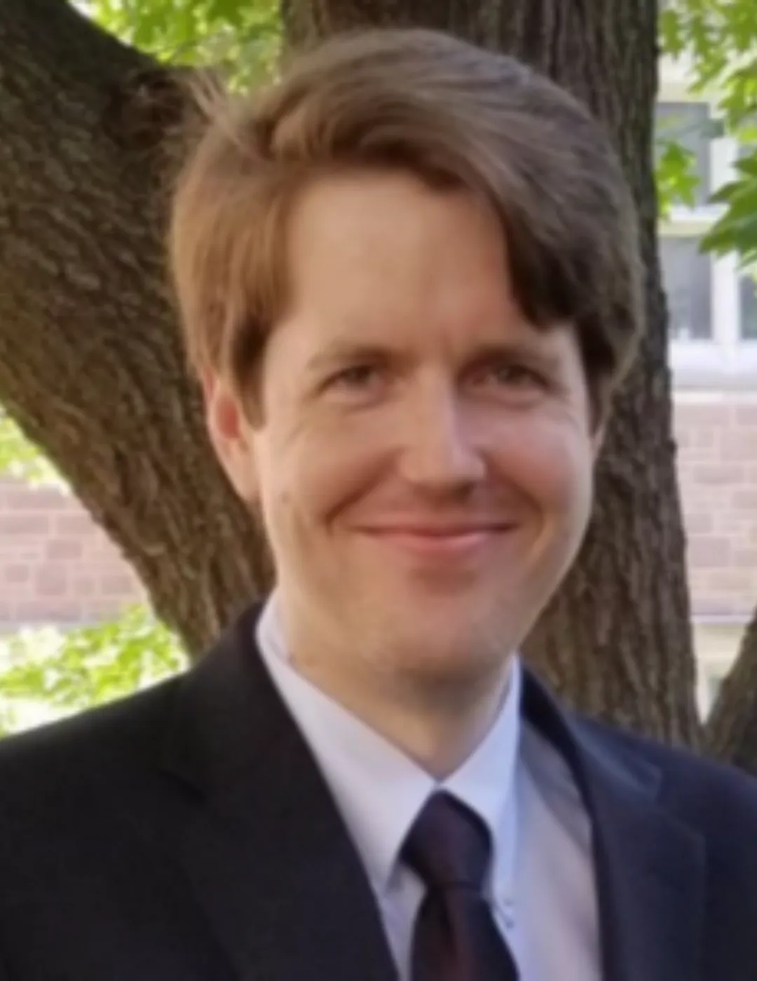 A headshot of Dr. Emfinger in a black suit