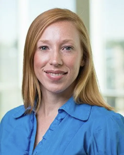 Sarah Sasse smiles for a headshot in a blue blouse