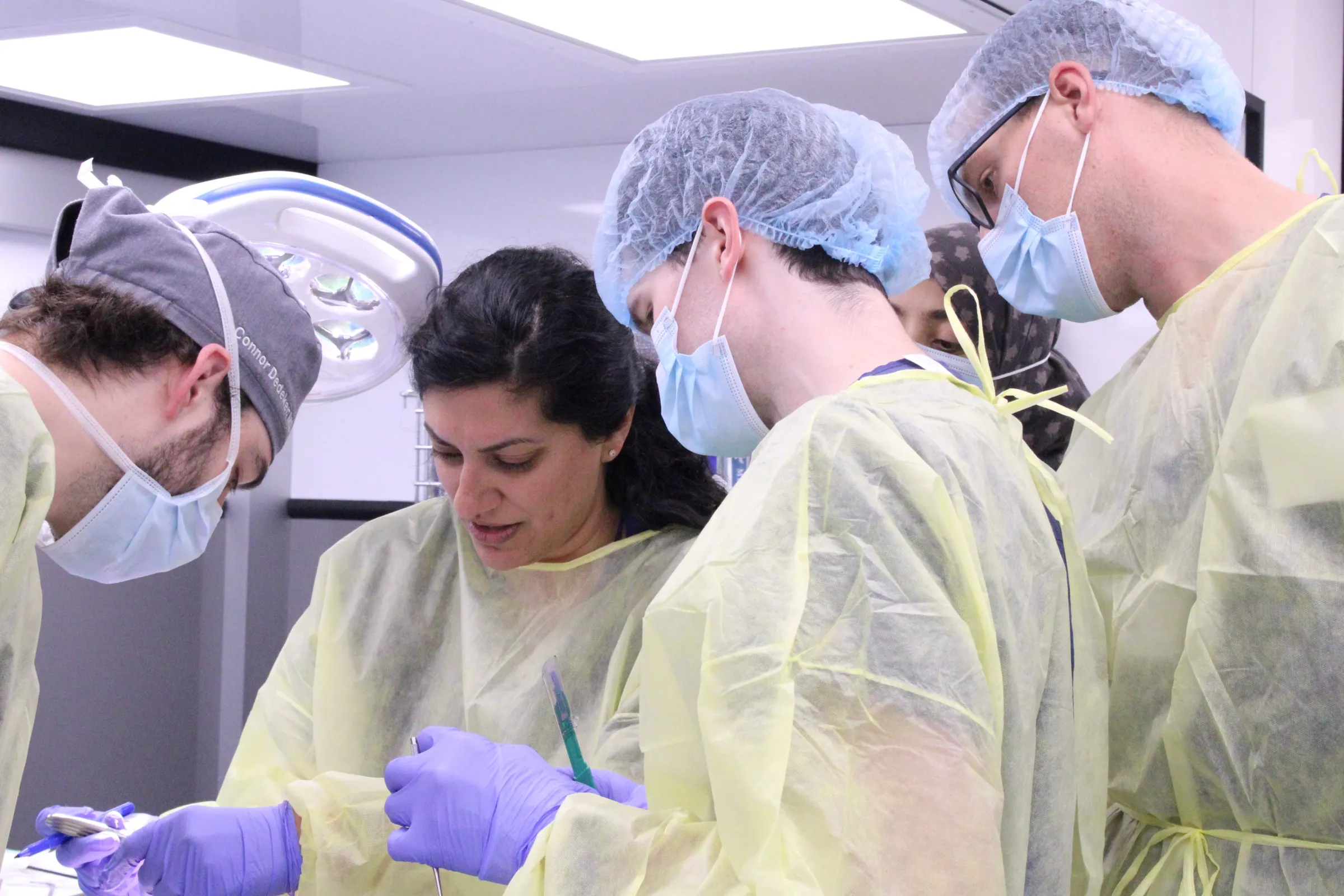 A close up of multiple otolaryngologists examining an object