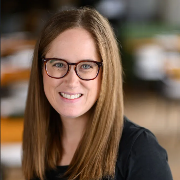 Dr. Lynden Bond, a woman with long straight brown hair and glasses