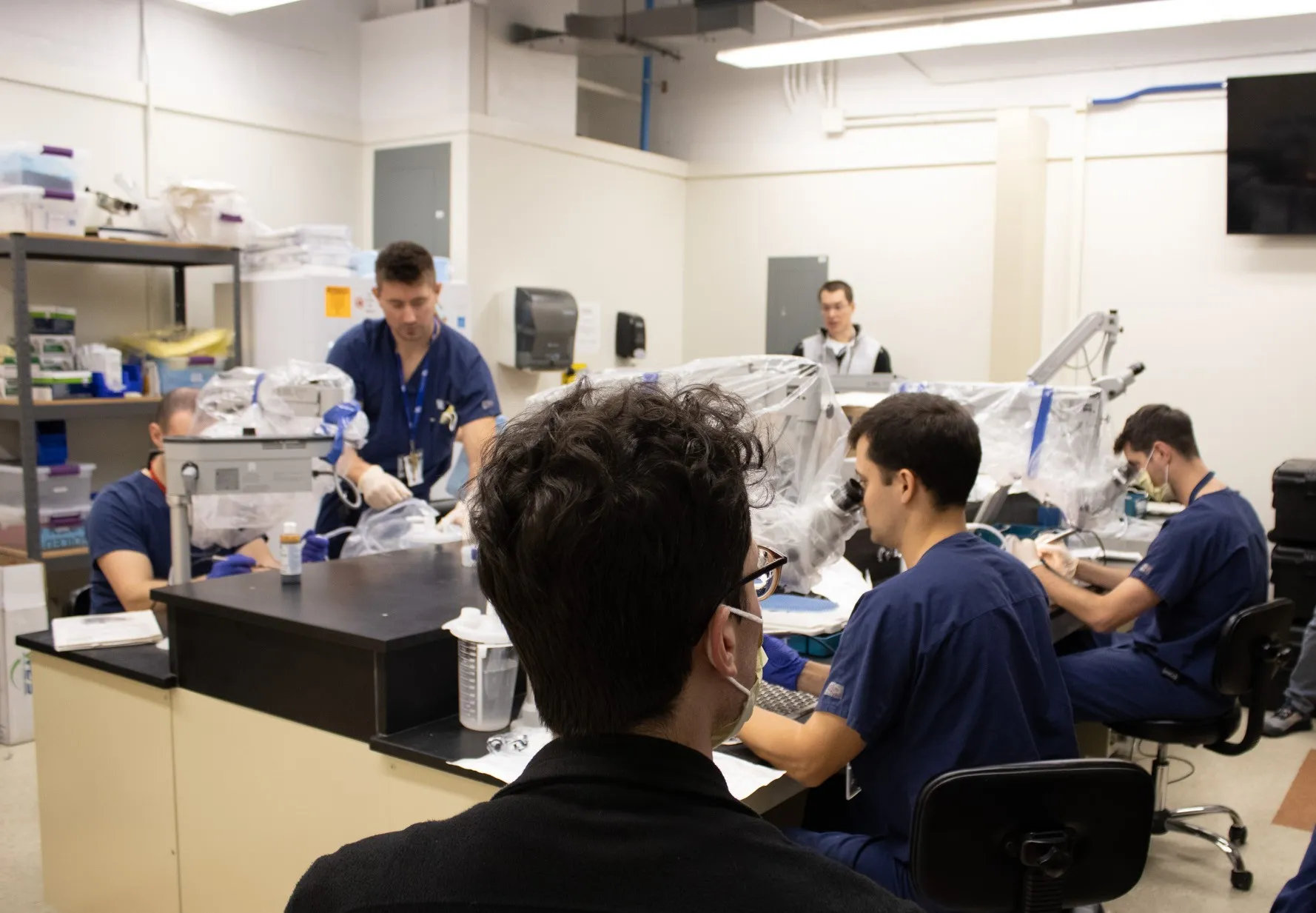 A group photo of Otology residents engaging in a simulation in the temporal bone lab