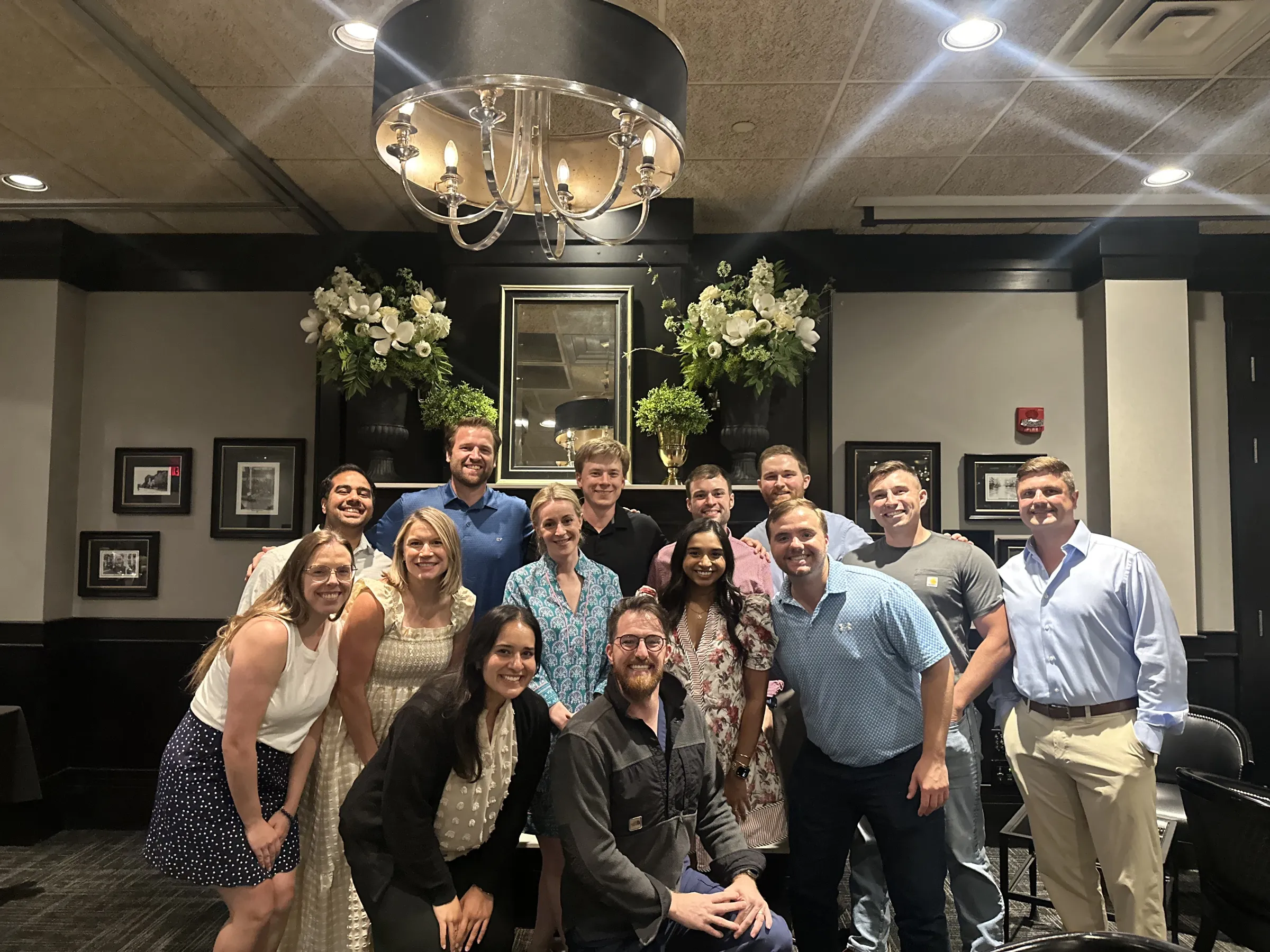 A group of track participants pose for a photo in a fancy establishment