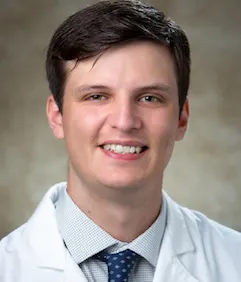 Cody Williams smiling in white coat