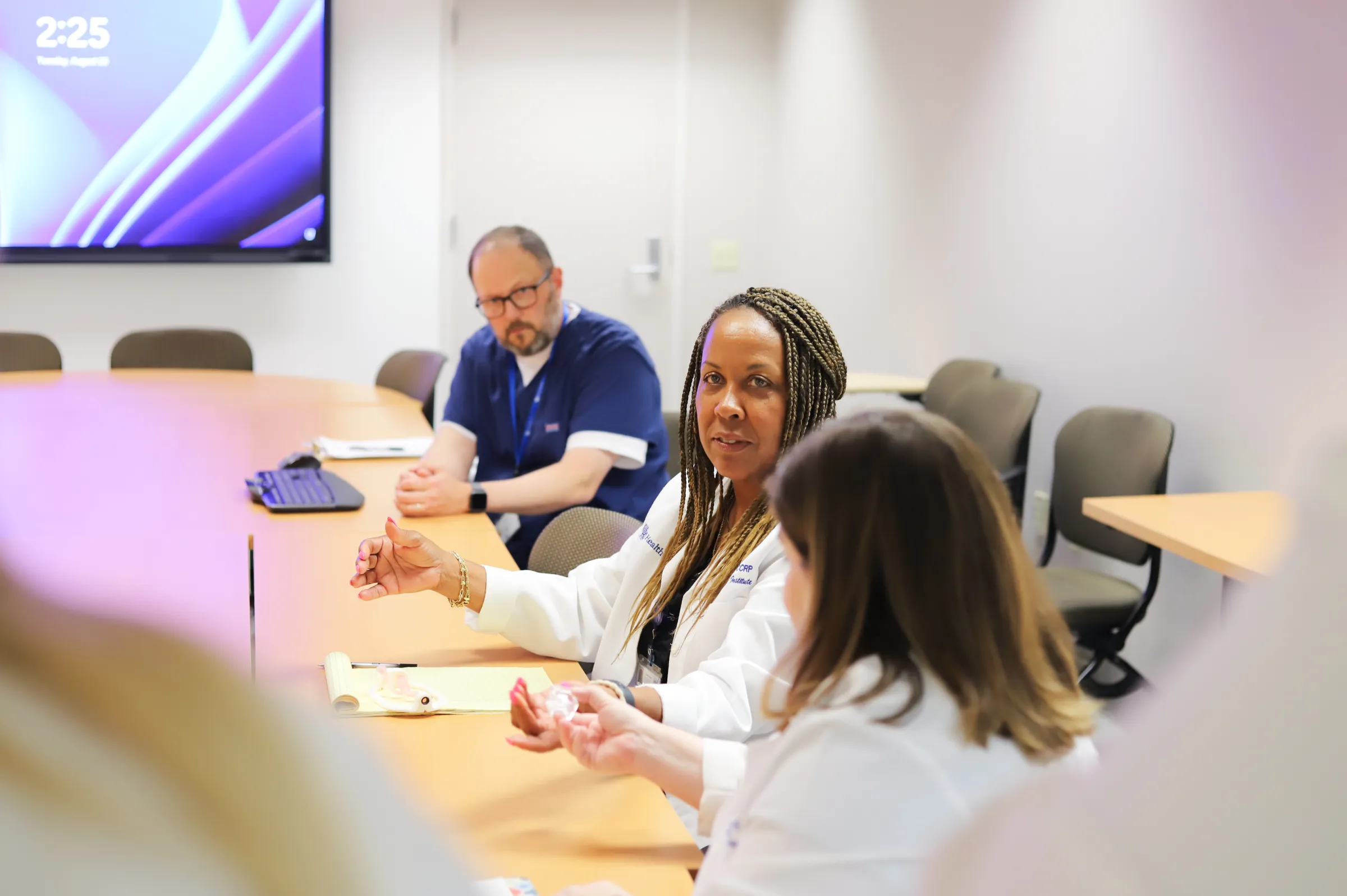 Doctor speaking at a table of other doctors