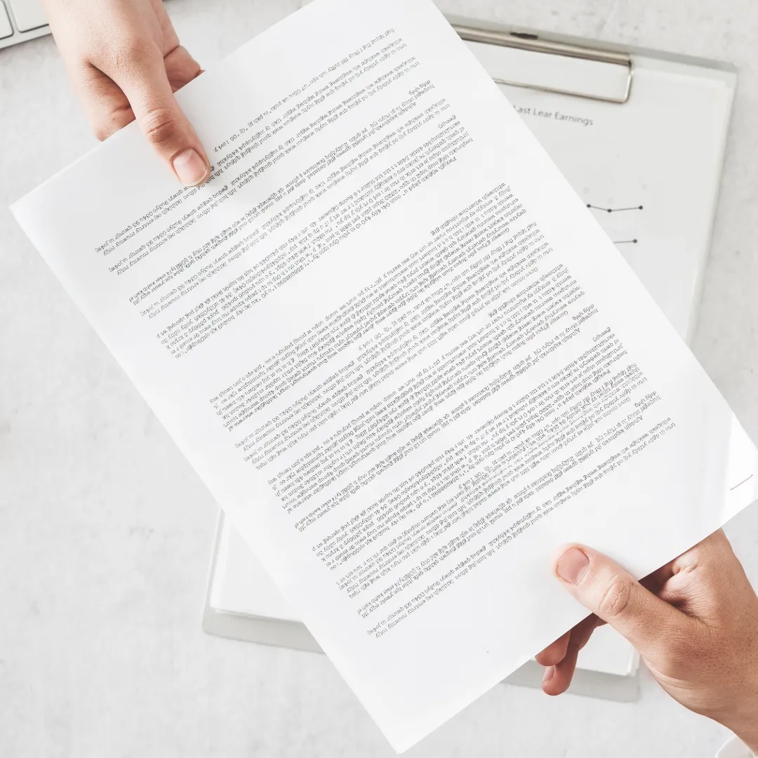 A paper with neat, printed text is being passed between hands