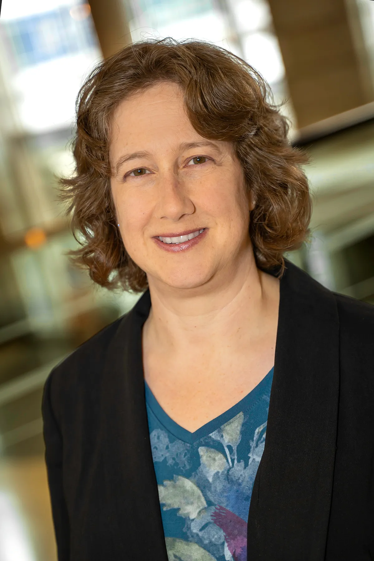 Doctor Shari Meyerson in business dress of a blue blazer and patterned green blouse